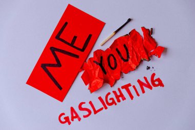 Pathological narcissism, narcissism and Gaslighting. Red paper with Me written on it, crumpled and torn red paper with You written on it, with Gaslighting written next to it in red on a white background. clipart