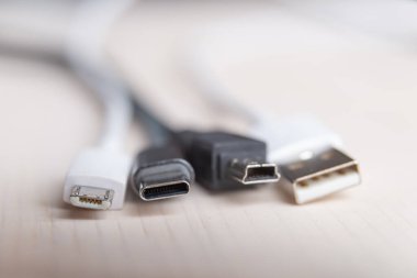 Mini USB, mikro USB ve USB tip-C bağlantı kabloları ile yakından fotoğraflanmıştır. USB konnektörlerinin evrimi ve değişimi.