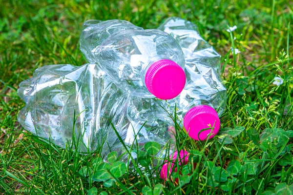 Transparent plastic bottles, abandoned in the environment. Plastic pollution and recycling.