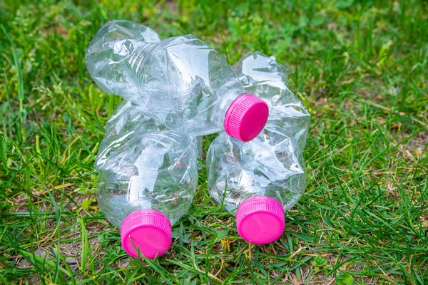 Transparent plastic bottles, abandoned in the environment. Plastic pollution and recycling.