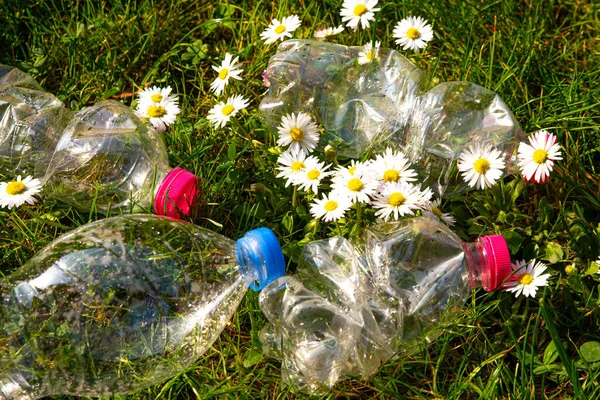 Transparent plastic bottles, abandoned in the environment. Plastic pollution and recycling.