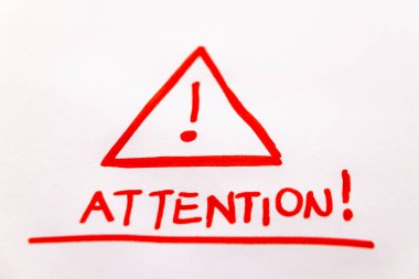 Dikkat levhası kırmızı kalemle çizilmiş ve beyaz bir kağıda 