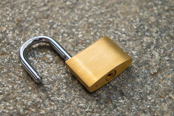 Open padlock, placed on the ground. Reopening, restart, freedom. 
