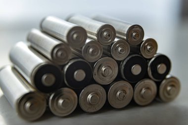 Bataryalar üst üste dizilmiş, hafif bir yüzeyde. Piller, enerji ve çevreye saygı. Alkali ya da şarj edilebilir piller. 
