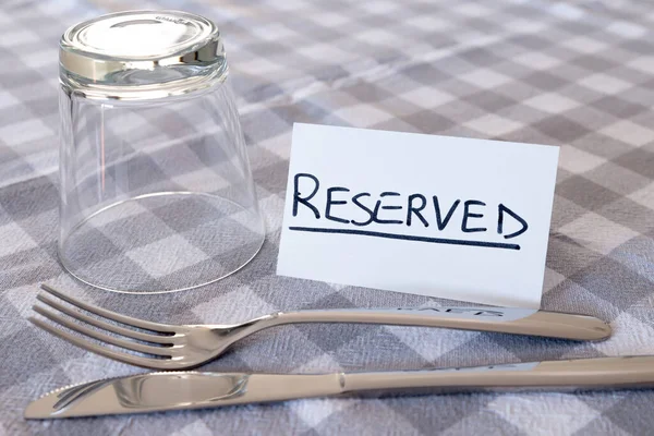 卡片与 灰色格子桌布 在餐馆预订餐桌 — 图库照片