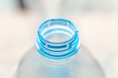 Temiz bir yüzeyde şeffaf plastik şişeler. Şeffaf şişe boyun. Tek kullanımlık plastiklerin geri dönüşümü ve bertaraf edilmesi. 