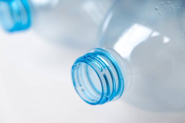 Temiz bir yüzeyde şeffaf plastik şişeler. Şeffaf şişe boyun. Tek kullanımlık plastiklerin geri dönüşümü ve bertaraf edilmesi. 