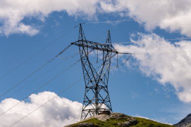 Elektrik direkleri, bir dağ yerinde. Köken, ulaşım ve elektrik ihtiyacı. Çevresel tahribat. Elektirik ızgarası.