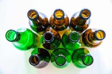 Beyaz yüzeyde boş bira ya da içecek şişeleri. Camların yeniden kullanılması ve geri dönüşümü. İsraf..