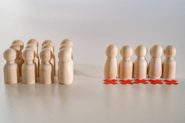 Kurumsal işten çıkarmaların ahşap piyonları ve kırmızı haçlarıyla kavramsal temsili. İşten çıkarmalar, personel kesintileri ve toplu işten çıkarmalar..