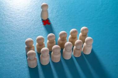 Kurumsal işten çıkarmaların ahşap piyonları ve kırmızı haçlarıyla kavramsal temsili. İşten çıkarmalar, personel kesintileri ve toplu işten çıkarmalar..