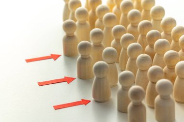 Tahta piyonlar sıraya dizilmiş bir aday havuzunu temsil ederken, bazıları da oklarla gösterilen sembolik olarak ilerliyorlar: yetenek seçimi ve en uygun profilleri belirleme süreci.