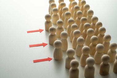 Tahta piyonlar sıraya dizilmiş bir aday havuzunu temsil ederken, bazıları da oklarla gösterilen sembolik olarak ilerliyorlar: yetenek seçimi ve en uygun profilleri belirleme süreci.