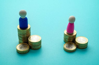 Kadınlar ve erkekler arasındaki iş yerinde eşit ücret kavramı. Cinsiyet Ödeme Boşluğu: Ahşap rakamlar ve bozuk para yığınları.