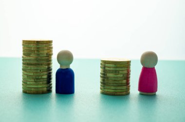 Kadınlar ve erkekler arasındaki iş yerinde eşit ücret kavramı. Cinsiyet Ödeme Boşluğu: Ahşap rakamlar ve bozuk para yığınları.