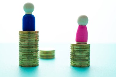 Kadınlar ve erkekler arasındaki iş yerinde eşit ücret kavramı. Cinsiyet Ödeme Boşluğu: Ahşap rakamlar ve bozuk para yığınları.