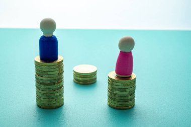 Kadınlar ve erkekler arasındaki iş yerinde eşit ücret kavramı. Cinsiyet Ödeme Boşluğu: Ahşap rakamlar ve bozuk para yığınları.