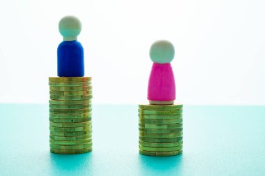 Kadınlar ve erkekler arasındaki iş yerinde eşit ücret kavramı. Cinsiyet Ödeme Boşluğu: Ahşap rakamlar ve bozuk para yığınları.