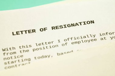 Employee resignation letter and pen beside.
