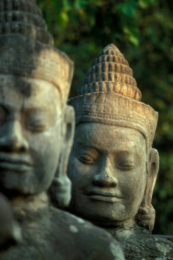 Kamboçya 'nın batısındaki Siem Reap şehrinin yakınlarındaki Angkor Tapınak Şehri' ndeki Angkor Tom şehrine giden güney kapısındaki köprüde taş bir yüz. Kamboçya, Siem Reap, Şubat 2001