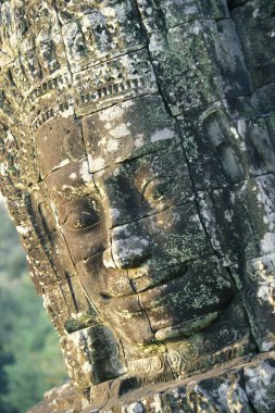 Kamboçya 'nın batısındaki Siem Reap şehrinin yakınlarındaki Angkor Tapınağı' ndaki Angkor Thom Tapınağı 'nın Tapınak Harabeleri' nde taş bir yüz. Kamboçya, Siem Reap, Şubat 2001
