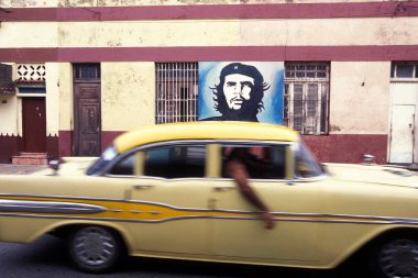 Bir duvarda Che Guevara 'nın resmi ve Karayip Denizi' nde Havana şehrinde eski bir Amerikan arabası. Küba, Havana, Ekim 2005