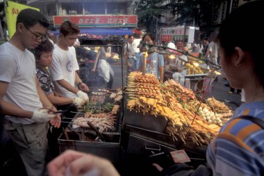 Deniz ürünleri ve et, Doğu Aasia 'nın Tayvan kentindeki Taipei şehir merkezinde bir gıda pazarında ızgara yapıyor. Tayvan, Taipei, Temmuz 1997 