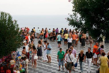 İtalya 'nın Sicilya ilya ilinin eski Taormina kasabasının merkezindeki Belvedere di Taormina' da günbatımında turistler görülüyor. İtalya, Sicilya, Ekim 2014