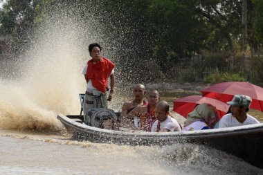 Passengers with red umbrellas on taxi motorboat