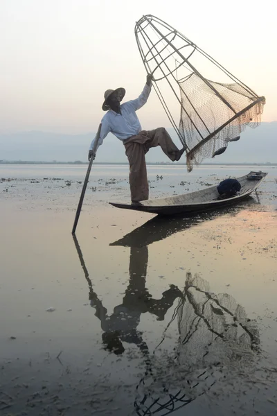 Рыбак на деревянной лодке с крелом — стоковое фото