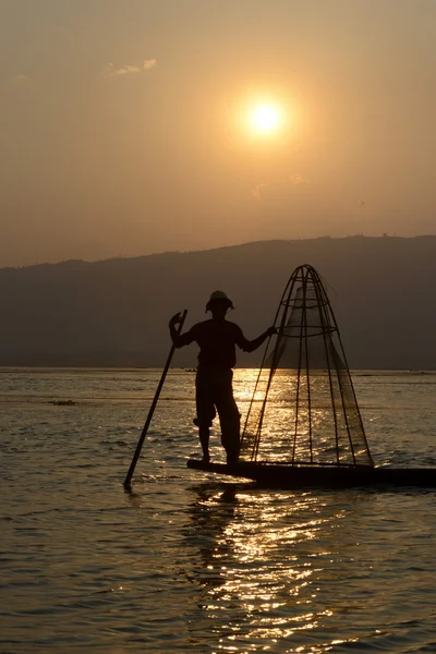 Рыбак на деревянной лодке с крелом — стоковое фото