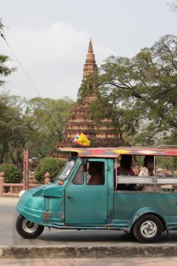 People on little car at ancient temple
