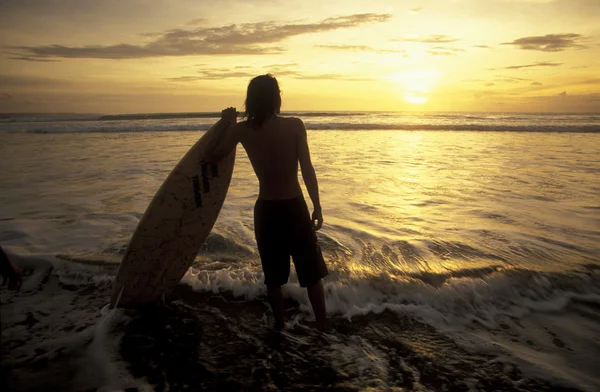 Uomo con tavola da surf sulla spiaggia — Foto Stock