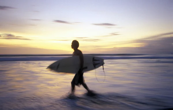 Homem com prancha de surf na praia — Fotografia de Stock