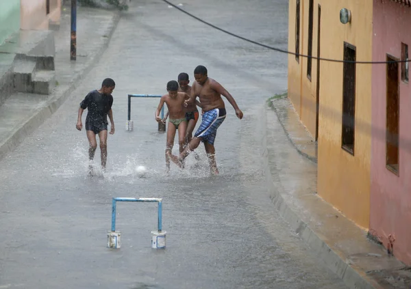 Niños juegan fútbol en la lluvia — Foto de Stock