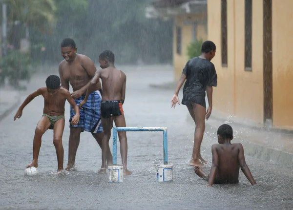 Дети играют в футбол под дождем — стоковое фото