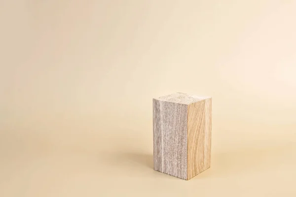 Natural wooden stand for presentation and exhibitions on pastel background. Abstract empty podium for organic cosmetic products. Minimal style.