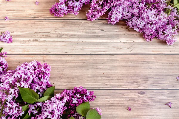 Lilac flowers on rustic wooden background. Top view, flat lay, copy space. Spring concept.