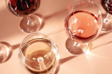 Kırmızı, gül ve beyaz şarap kadehleri. Gölge etkisi yaratıyor. Şarap tatma kavramı. Düz yatış, üst görünüm.