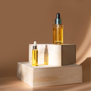 Kozmetik yağlı cam damlatan şişeler, gerekli ya da gölgeli ahşap ayakta duran serumlar. Doğal organik kozmetik kavramı. Bitkisel homeopatik ürünler.