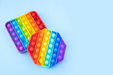 Renkli stres önleyici hareketler mavi arka planda izole edilmiş duyusal oyuncaklar. Basit bir gamze. Üst görünüm, düz görünüm, kopyalama alanı. Seçici odak.