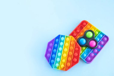 Renkli stres önleyici hareketler mavi arka planda izole edilmiş duyusal oyuncaklar. Basit bir gamze. Üst görünüm, düz görünüm, kopyalama alanı. Seçici odak.