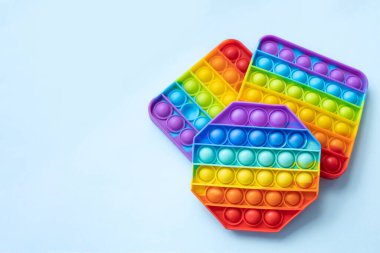 Renkli stres önleyici hareketler mavi arka planda izole edilmiş duyusal oyuncaklar. Basit bir gamze. Üst görünüm, düz görünüm, kopyalama alanı. Seçici odak.