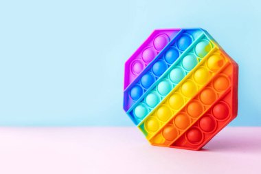 Renkli stres önleyici hareketler mavi ve pembe arka planda izole edilmiş duyusal oyuncaklar. Basit bir gamze. Üst manzara, düz yatış. Seçici odak.