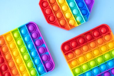 Renkli stres önleyici hareketler mavi arka planda izole edilmiş çocuklar için duyusal oyuncaklar. Basit bir gamze. Üst manzara, düz yatış. Seçici odak.