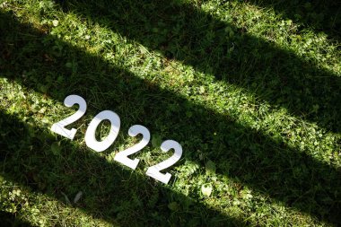Mutlu yıllar 2022. 2022 numaralı beyaz tahta yeşil çimlerin üzerinde. Pankart. Boşluğu kopyala