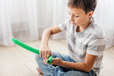 Renkli stres önleyici hareketler çocuklar için pop tüpü oyuncakları itiyor. Çocukların elinde esnek kıvrımlı boru. Duyusal oyuncaklarla oynayan çocuk. Hayal gücünü geliştirmek ve motor becerilerini geliştirmek için eğlenceli oyun..