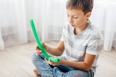 Renkli stres önleyici hareketler çocuklar için pop tüpü oyuncakları itiyor. Çocukların elinde esnek kıvrımlı boru. Duyusal oyuncaklarla oynayan çocuk. Hayal gücünü geliştirmek ve motor becerilerini geliştirmek için eğlenceli oyun..