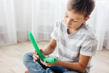 Renkli stres önleyici hareketler çocuklar için pop tüpü oyuncakları itiyor. Çocukların elinde esnek kıvrımlı boru. Duyusal oyuncaklarla oynayan çocuk. Hayal gücünü geliştirmek ve motor becerilerini geliştirmek için eğlenceli oyun..