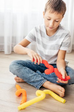 Renkli stres önleyici hareketler çocuklar için pop tüpü oyuncakları itiyor. Çocukların elinde esnek kıvrımlı boru. Duyusal oyuncaklarla oynayan çocuk. Hayal gücünü geliştirmek ve motor becerilerini geliştirmek için eğlenceli oyun..
